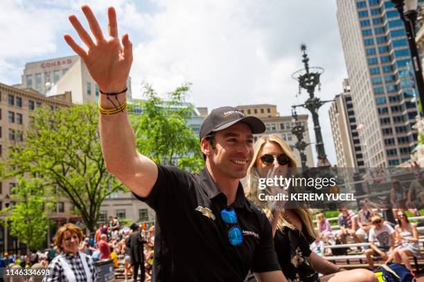 Simon Pagenaud and girlfriend Hailey McDermott wave to the crowd during the 103rd Indy 500 Festival Parade on May 26, 2019 in Indianapolis, Indiana.