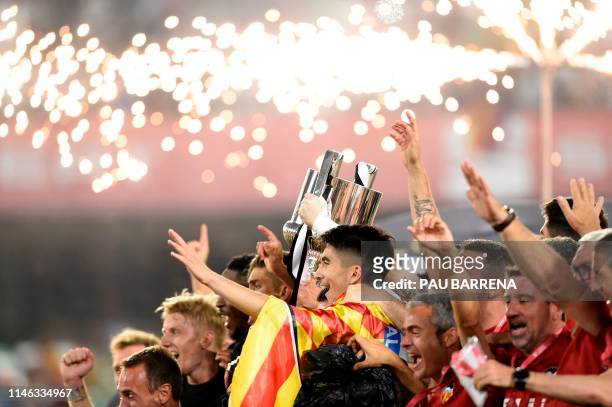 Valencia's players celebrates with the trophy after winning the 2019 Spanish Copa del Rey final football match against Barcelona at the Benito...