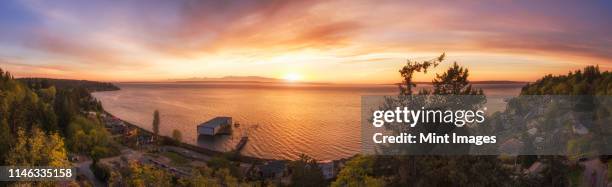 panoramic view of sunset over lake in remote landscape - edmonds foto e immagini stock