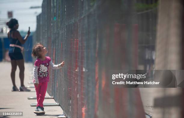 Three-year-old Laylani Jeniya-Smith Edgecomb looks through the chainlink fence that separates counter protesters from a protest against a rally held...