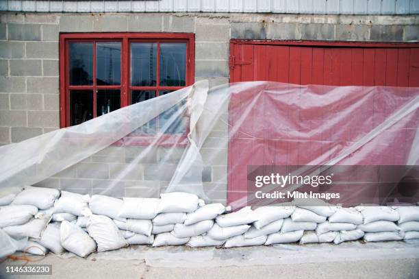 sandbags and glass sheet on building wall - sandbag - fotografias e filmes do acervo