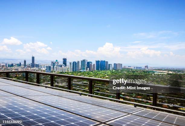 solar panels and manila cityscape under blue sky, philippines - philippines stock pictures, royalty-free photos & images