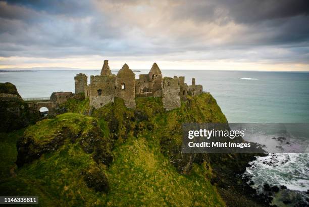 castle ruins on cliff at ocean - dunluce castle stockfoto's en -beelden