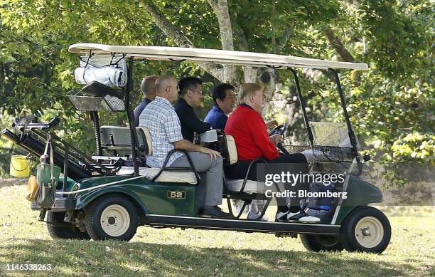 President Donald Trump, right, and Shinzo Abe, Japan's prime minister, second right, sit in a golf cart at Mobara Country Club in Mobara, Chiba...