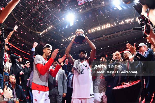 Kawhi Leonard of the Toronto Raptors celebrates holding the Eastern Conference Championship trophy after a game against the Milwaukee Bucks after...