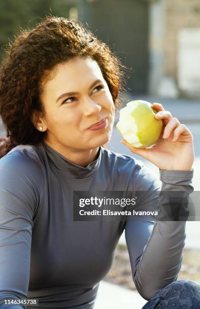 jeune femme mangeant une pomme - pomme croquée photos et images de collection