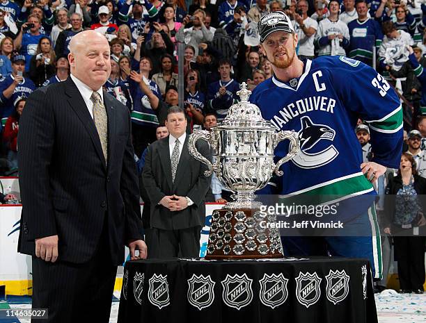 Henrik Sedin of the Vancouver Canucks is presented the the Clarence S. Campbell Bowl by NHL Deputy Commissioner Bill Daly after their 3-2 overtime...
