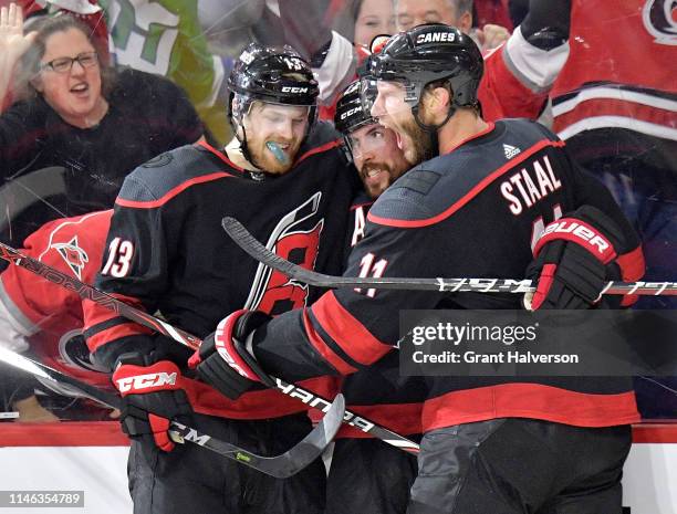 Justin Faulk celebrates with Warren Foegele and Jordan Staal of the Carolina Hurricanes after scoring against the New York Islanders during the...