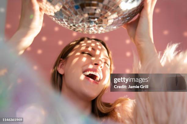 smiling young woman holding mirror ball - grill party stockfoto's en -beelden