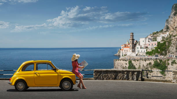 woman holding map leaning on yellow car in atrani, italy - italy stock pictures, royalty-free photos & images