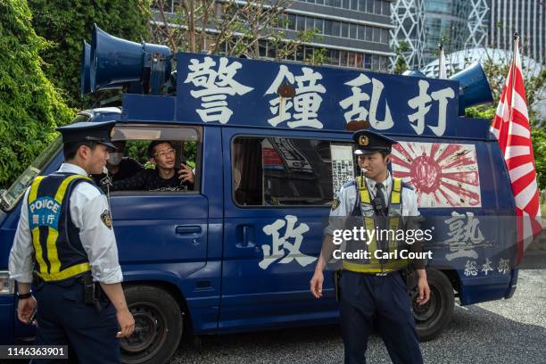 Police officers stop a vehicle driven by right wing, nationalist protesters as people pass by demonstrating against U.S president Donald Trump's...
