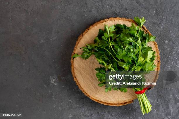 bunch of parsley on cutting board - parsley stock pictures, royalty-free photos & images