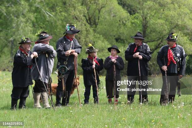 May 2019, Saxony-Anhalt, Tanne: Cow herders stand with their staffs at the "Kuhball" on a meadow in the Oberharzort. A thousand people gathered in...