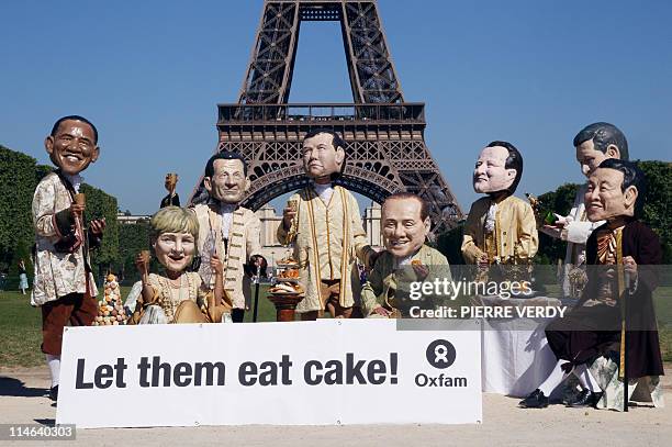 Activists of humanitarian NGO Oxfam wearing giant papier mache heads representing President of the United States Barack Obama, Chancellor of Germany...