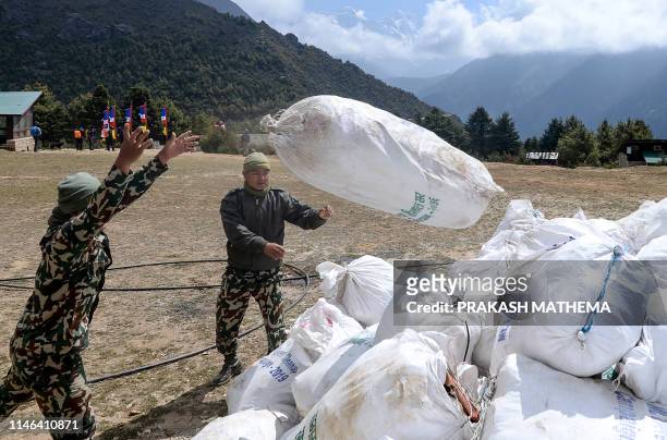 Nepali Army personnel throw bags of waste collected from the Mount Everest at Namche Bazar, on May 27 before it is transported to Kathmandu to be...