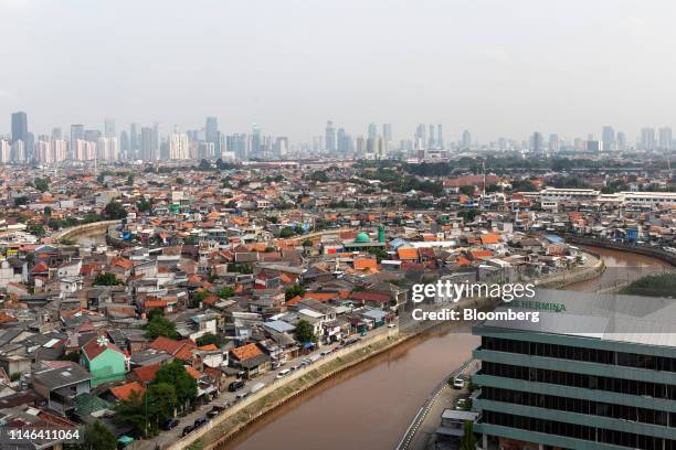 Skyscrapers are seen beyond residential buildings standing in the Jatinegara district of East Jakarta, Indonesia, on Friday, May 10, 2019....
