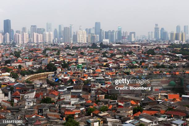 Skyscrapers are seen beyond residential buildings standing in the Jatinegara district of East Jakarta, Indonesia, on Friday, May 10, 2019....