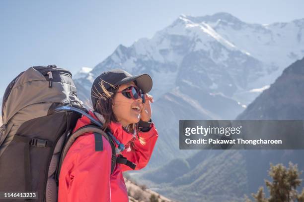 portrait of young asian woman hiking mountains in nepal - nepal trekking stock-fotos und bilder