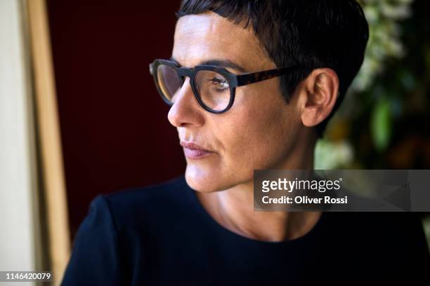 portrait of serious short-haired woman wearing glasses looking away - pensive bildbanksfoton och bilder