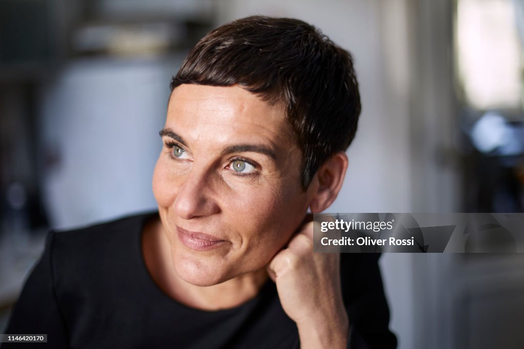 Portrait of smiling short-haired woman at home looking away