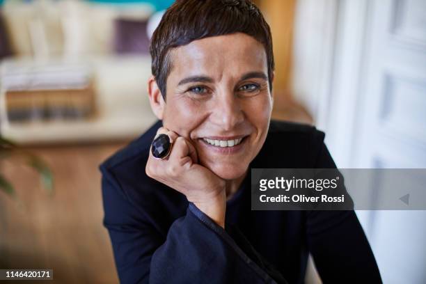 portrait of smiling short-haired woman at home - hand on chin stock pictures, royalty-free photos & images