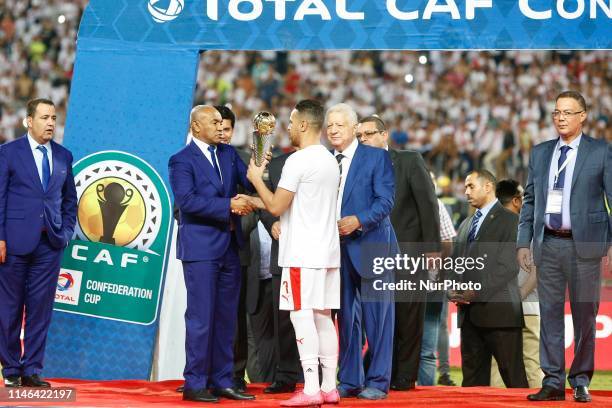 Egypt's Zamalek player Hazem Emam receives the trophy from the president of the African Football Federation Ahmed Ahmed after they won the CAF...