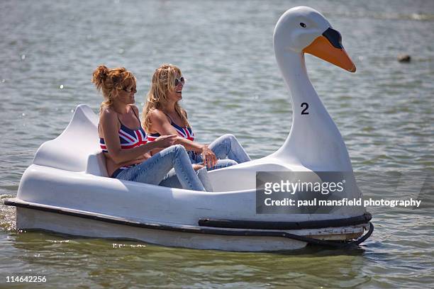 sisters share swan shaped pedalo - paddleboat stock pictures, royalty-free photos & images
