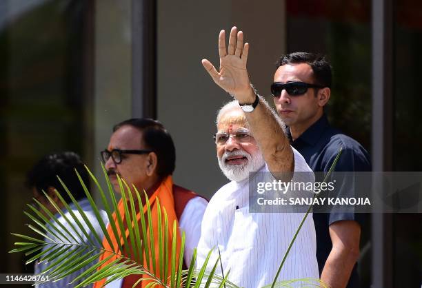 Indian Prime Minister Narendra Modi waves to supporters at the Trade Facilitation Center And Craft Museum after offering prayers at Kashi Vishwanath...