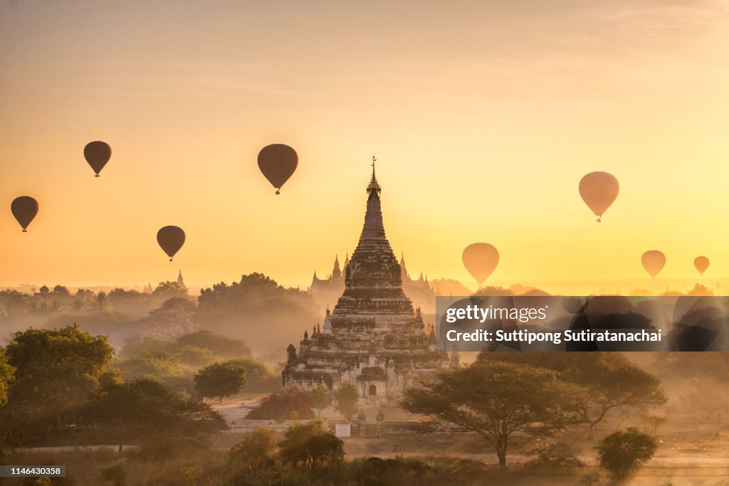 Tourist hot air balloon over Ancient Pagoda at Bagan in Myanmar, tourists watching sunrise over ancient city