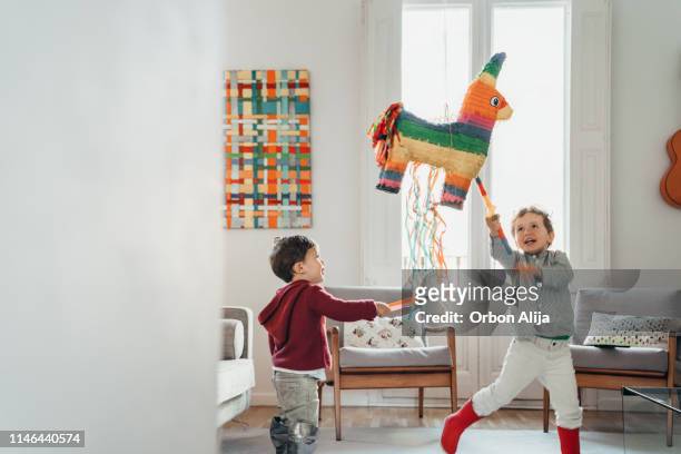 jungs brechen piñata auf einer party - piñata stock-fotos und bilder