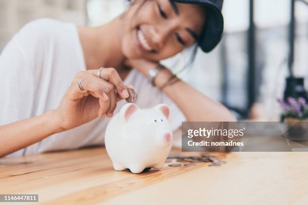 piggy bank for saving money.hand holding money for savings and financial management. - sparsamkeit stock-fotos und bilder