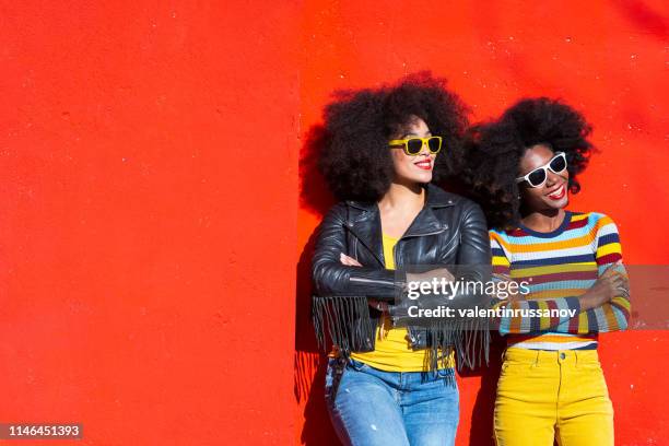 cheerful afro women standing together and smiling on colorful backgraund - family on coloured background stock pictures, royalty-free photos & images