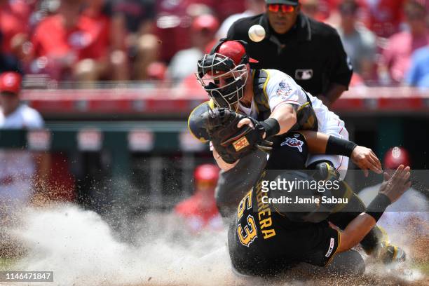 Melky Cabrera of the Pittsburgh Pirates scores a run in the fourth inning as he collides with catcher Tucker Barnhart of the Cincinnati Reds at Great...