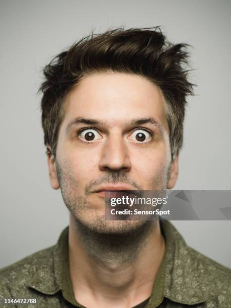 verdadero hombre caucásico con expresión sorprendida mirando a la cámara - man face fotografías e imágenes de stock