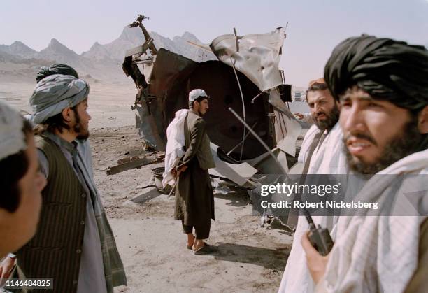 Taliban intelligence personnel check on a bombed container in Kandahar, Afghanistan on November 1, 2001. U.S. Military and NATO war planes began...