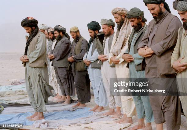 Taliban offer afternoon prayers near Chokar Karez, Afghanistan, approximately 80 km north of Kandahar, on November 1, 2001. U.S. Air military and...