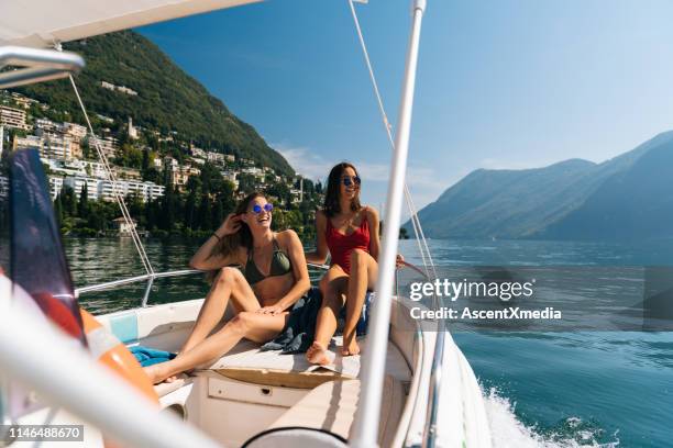 zwei junge frauen entspannen sich auf boot - lugano stock-fotos und bilder