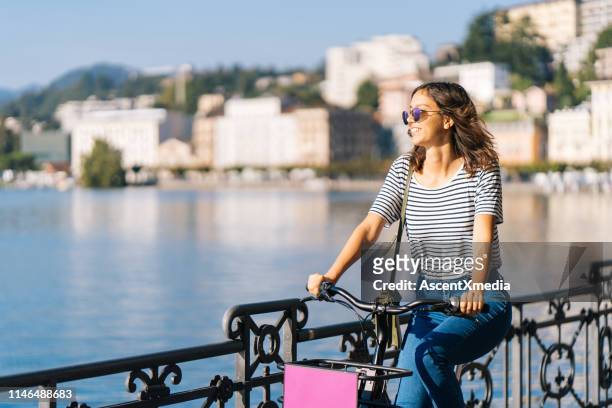 a mulher nova monta a bicicleta e os sorrisos - lugano - fotografias e filmes do acervo