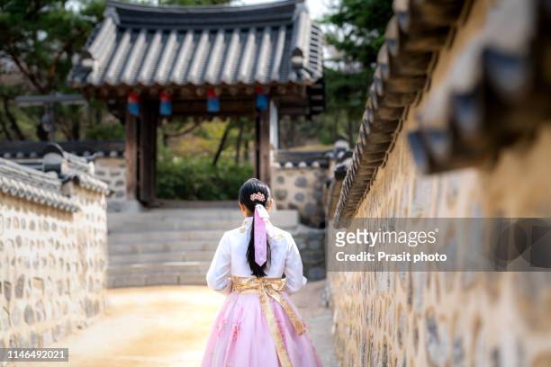 back of asian woman wearing hanbok walking through the seoul traditional style houses of namsan hanok village in seoul, south korea. - korean teen bildbanksfoton och bilder