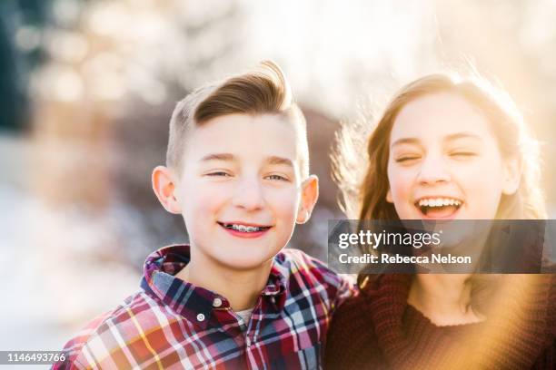 outdoor portrait of brother and sister twins - girl 11 12 laughing close up foto e immagini stock