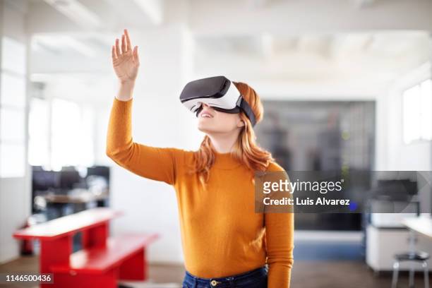 curious businesswoman using vr goggles - simulador de realidade virtual - fotografias e filmes do acervo
