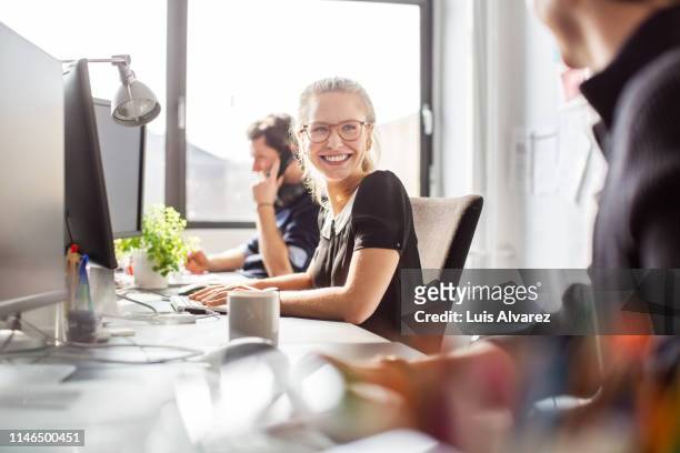 happy young businesswoman coworking with her team - ethnische zugehörigkeit stock-fotos und bilder