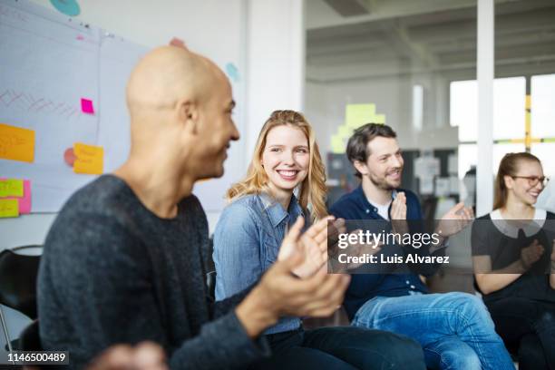 smiling business people clapping hands - motivation stock-fotos und bilder