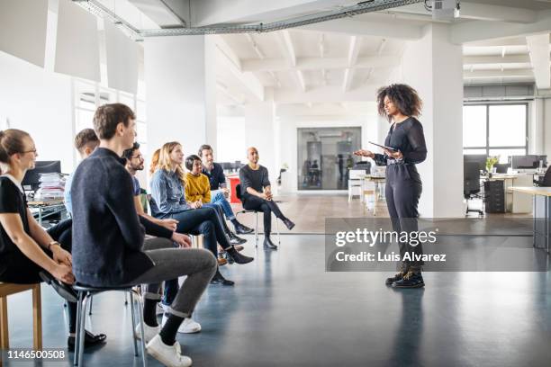 woman addressing her team - ponencia fotografías e imágenes de stock