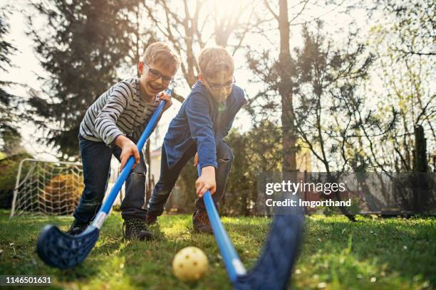 kleine jongens spelen floorball in de achtertuin - hockey goal stockfoto's en -beelden