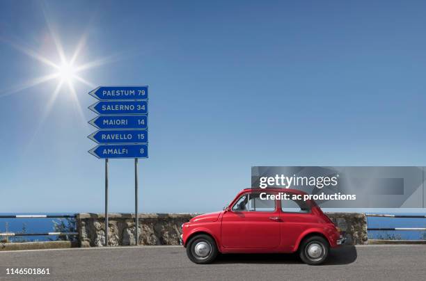 red car by road sign on amalfi coast, italy - segnaletica stradale foto e immagini stock