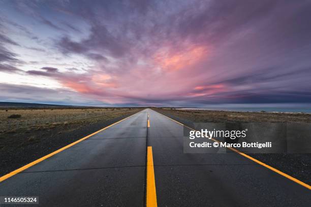 empty paved road at sunset in the chilean patagonia - horizont stock-fotos und bilder