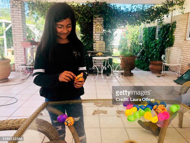 girl opening easter egg containing money - easter egg hunt outside stock pictures, royalty-free photos & images