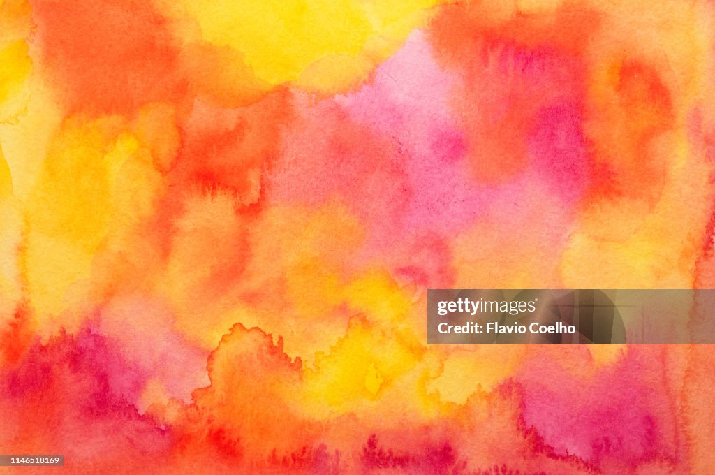 Watercolor background in yellow, red, orange and pink tones