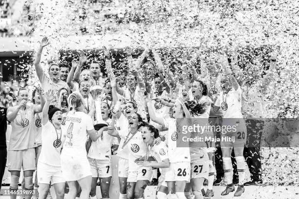 Nilla Fischer of VfL Wolfsburg holds a trophy as players celebrate during medal ceremony after the Women's DFB Cup final match between VfL Wolfsburg...